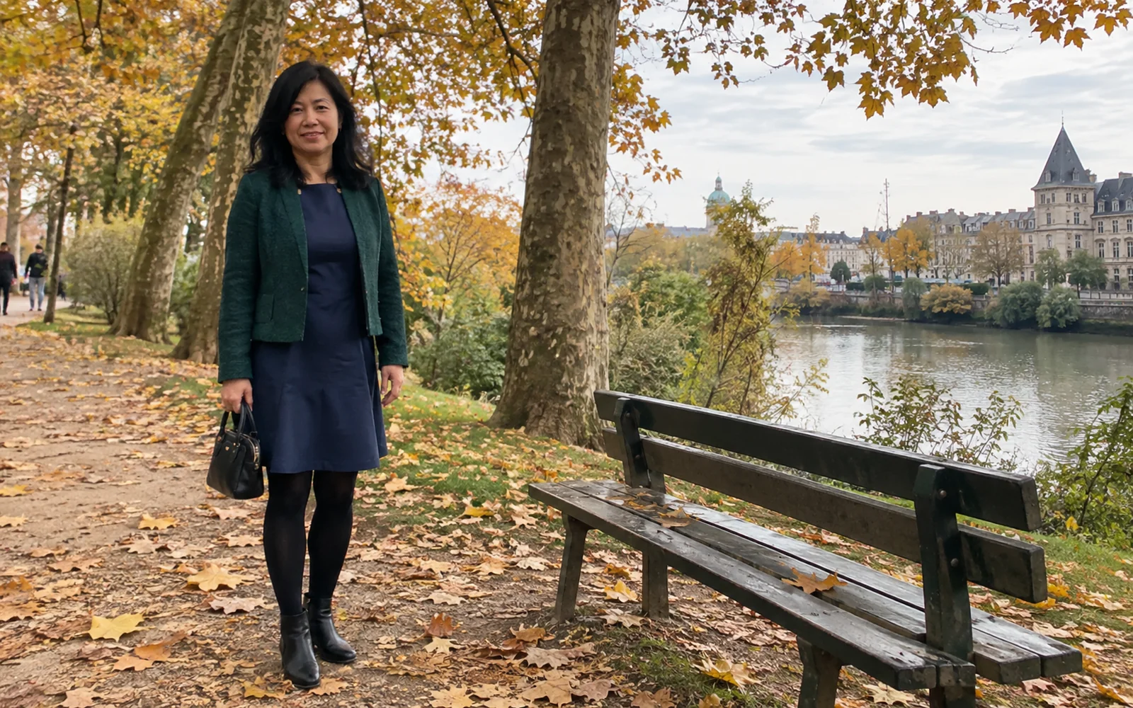 Femme en robe marine, veste verte, collants noirs et bottines dans un parc